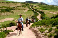 Turistas galopando en sus caballos hacia Moray