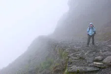 Mujer parada entre la neblina en la ruta del Choro