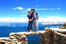 Pareja parada sobre un muro en las ruinas de Pilcocaina