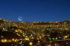 Moon rising over the city of La Paz, Bolivia in the night.