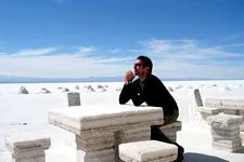 Man sitting at salt table in Uyuni Salar Salt Flats near Pot