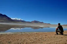 Trekker at high-altitude pristine Lake Isca Khota near La Pa