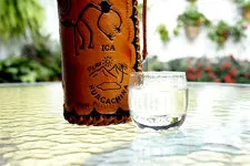 Bottle of Pisco with serving cup in Ica, Peru.