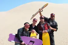 Group photo during extreme sandboarding adventure on White H